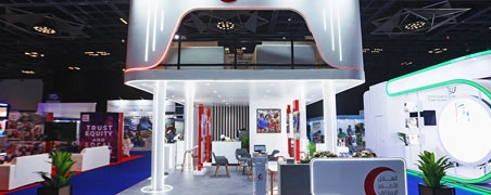 Healthcare exhibition stand with curved white canopy and open meeting counters